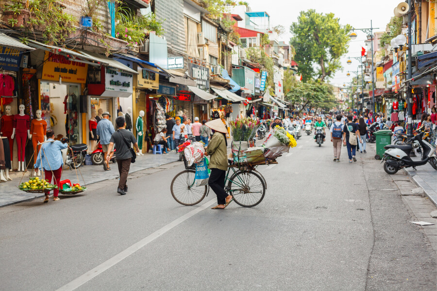 The busy Old Quarter street with silk shops, cafes, bike vendors and tourists