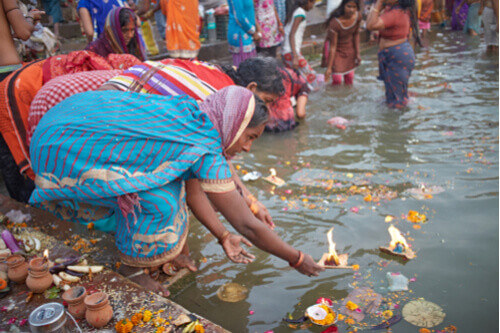 A local woman puts an offering on the water in Varanasi.