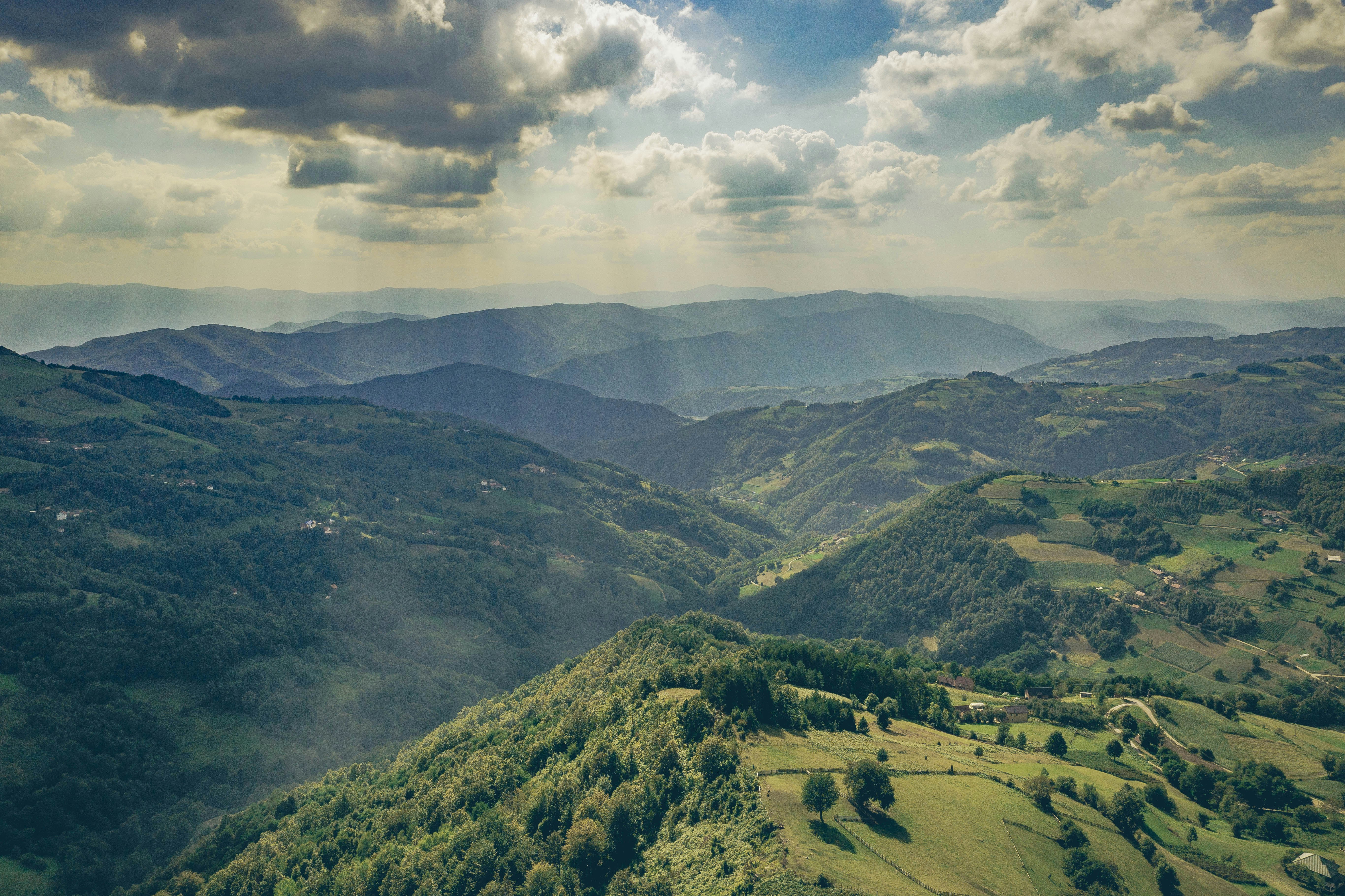 Viewpoint at Kapija Podrinja near Ovčinja, Serbia, overlooking green valleys and the distant Balkan mountains under a bright blue sky.
