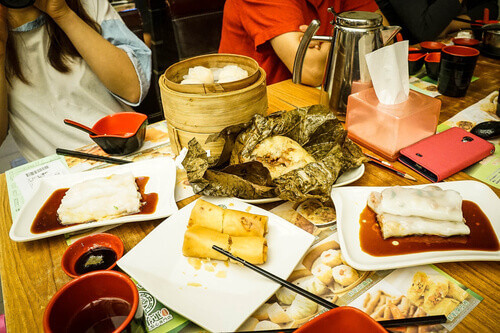 Assorted dim sum dishes on a table in Hong Kong, including dumplings, buns, and steamed rolls