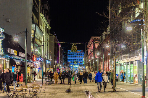 People walking in the Austurstraeti street on a winter evening.