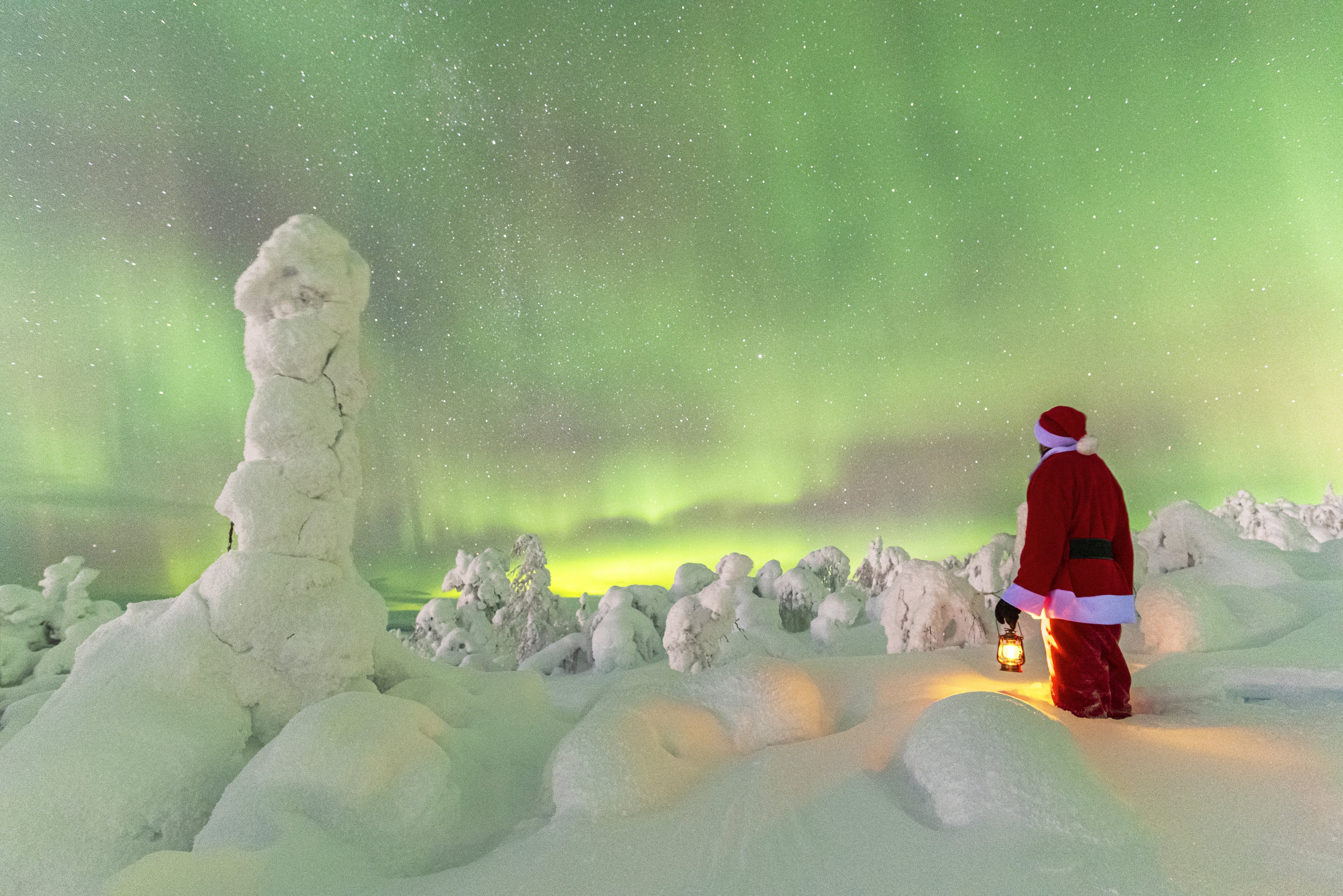 Santa Claus gazing at the Northern Lights in Finnish Lapland&mdash;an enchanting highlight of Finland tourism in winter.
