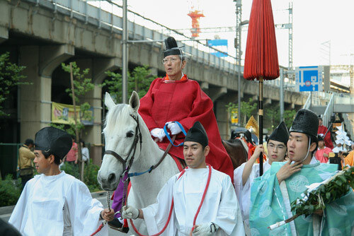 A local man wears a samurai costume on horseback during a parade.