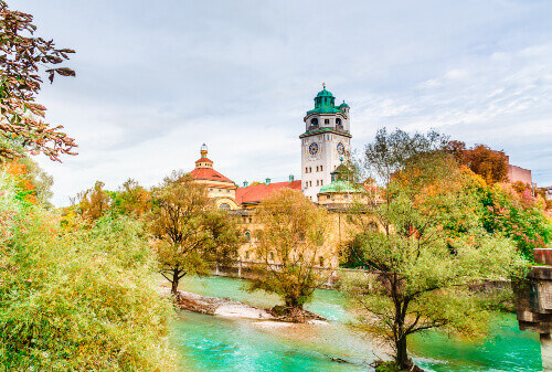 The autumn view of the Isar River with the neo-baroque Muellersches Volksbad in sight.