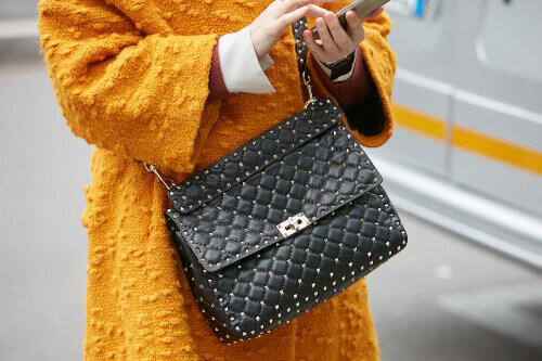Woman with a black designer leather bag in Milan.