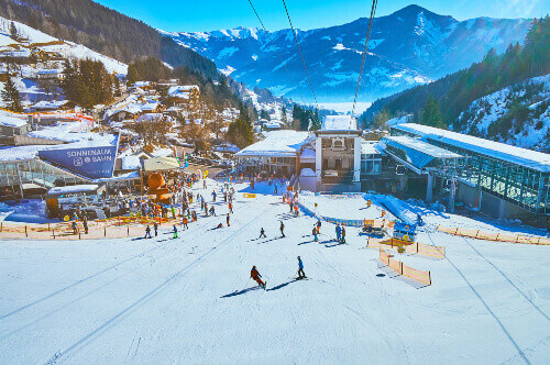 The Alps with people skiing and snowboarding in Zell Am See.