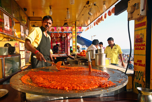 A local man cooks in a street food stall.