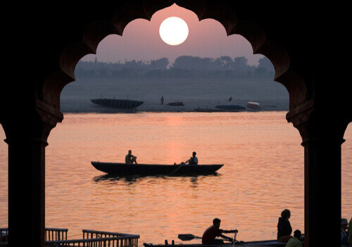 A small boat on the Ganges River at sunset.