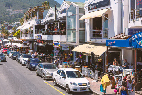 Street of Camps Bay with lots of resturants and cafes and crowded with tourists in Cape Town South Africa