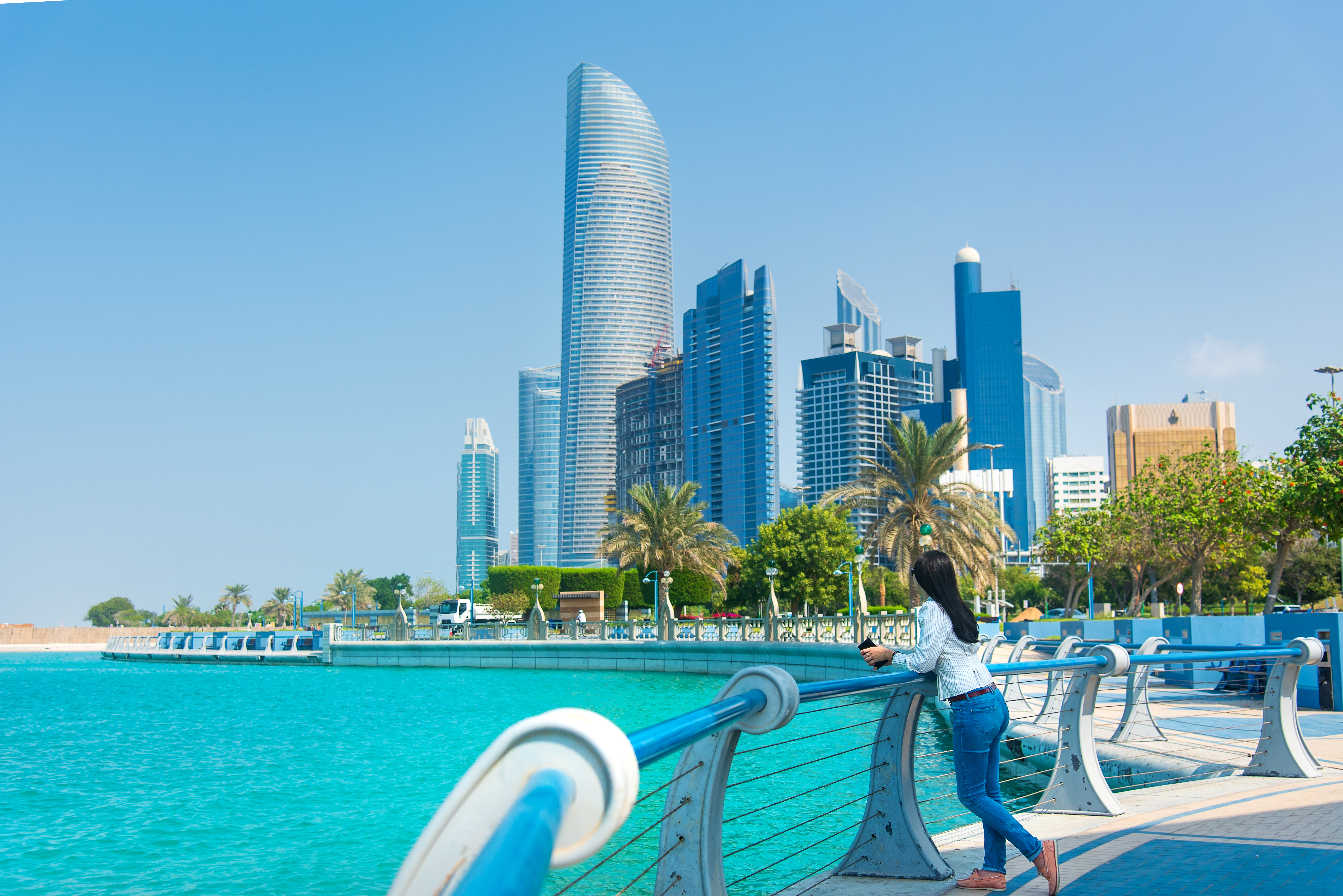 A visitor takes in the scenic Abu Dhabi Corniche, perfect for a relaxed stopover stroll by the sea