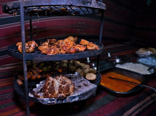 Zarb: A Jordanian Bedouin barbecue cooked underground with lamb and vegetables, served at traditional camps in Wadi Rum.