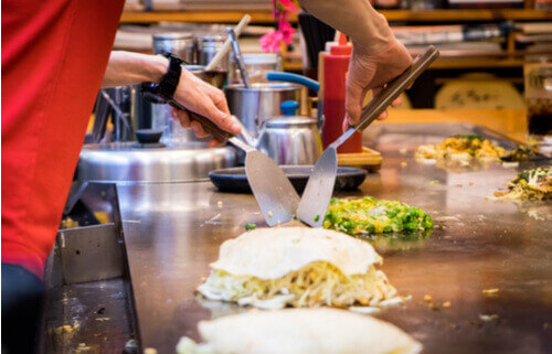 A local cooks Okonomiyaki in Hiroshima, Japan.