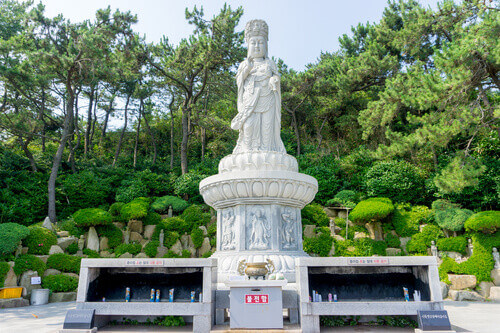 Guanyin or Guan Yin Goddess of Mercy white statue on the top of the hill at Haedong Yonggungsa Temple in Busan, South Korea.