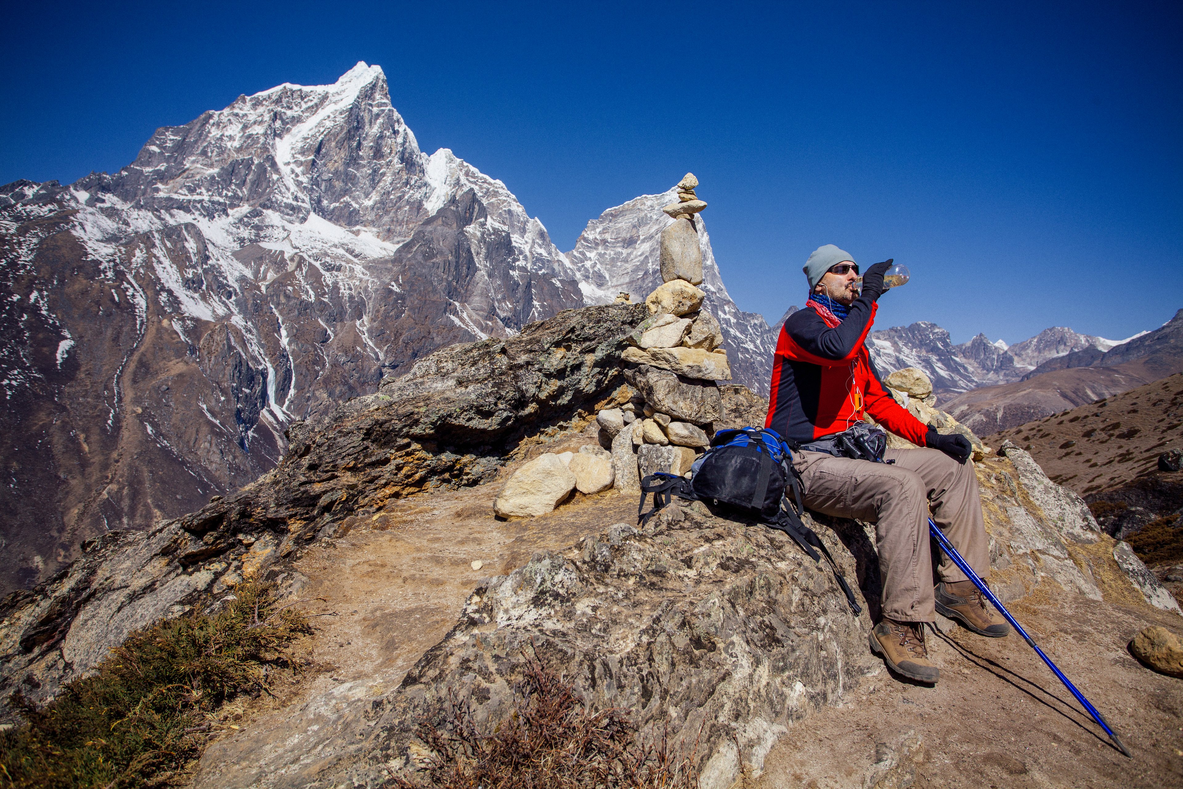 A hiker rests high in the Himalayas, surrounded by Nepal&rsquo;s majestic peaks