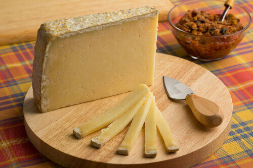 French Cantal Aop cheese on a cutting board