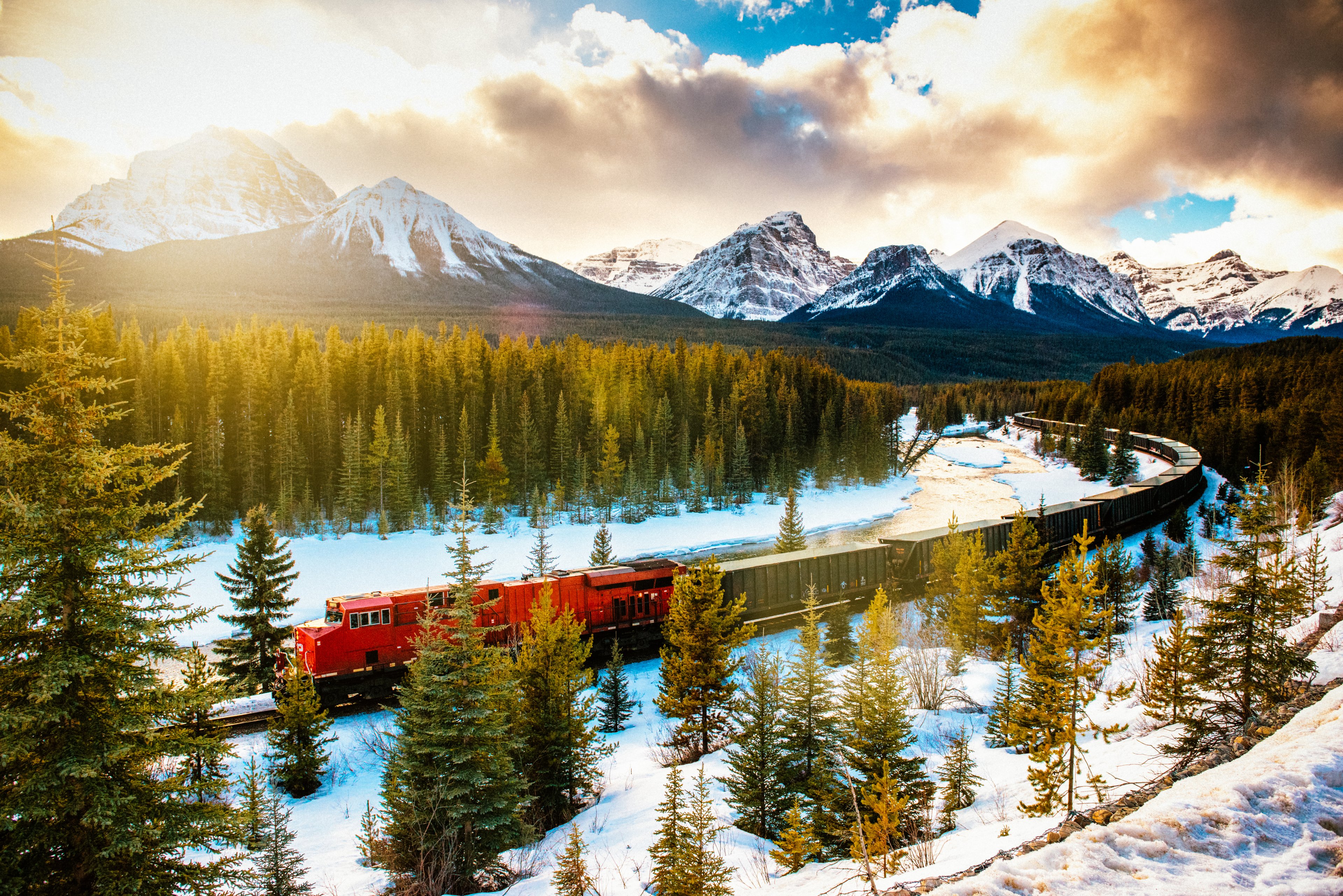 Rocky Mountaineer train passing through forested mountain landscape