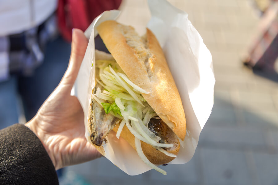 Turkish street food of fish sandwich with onions and greens called Balik Ekmek