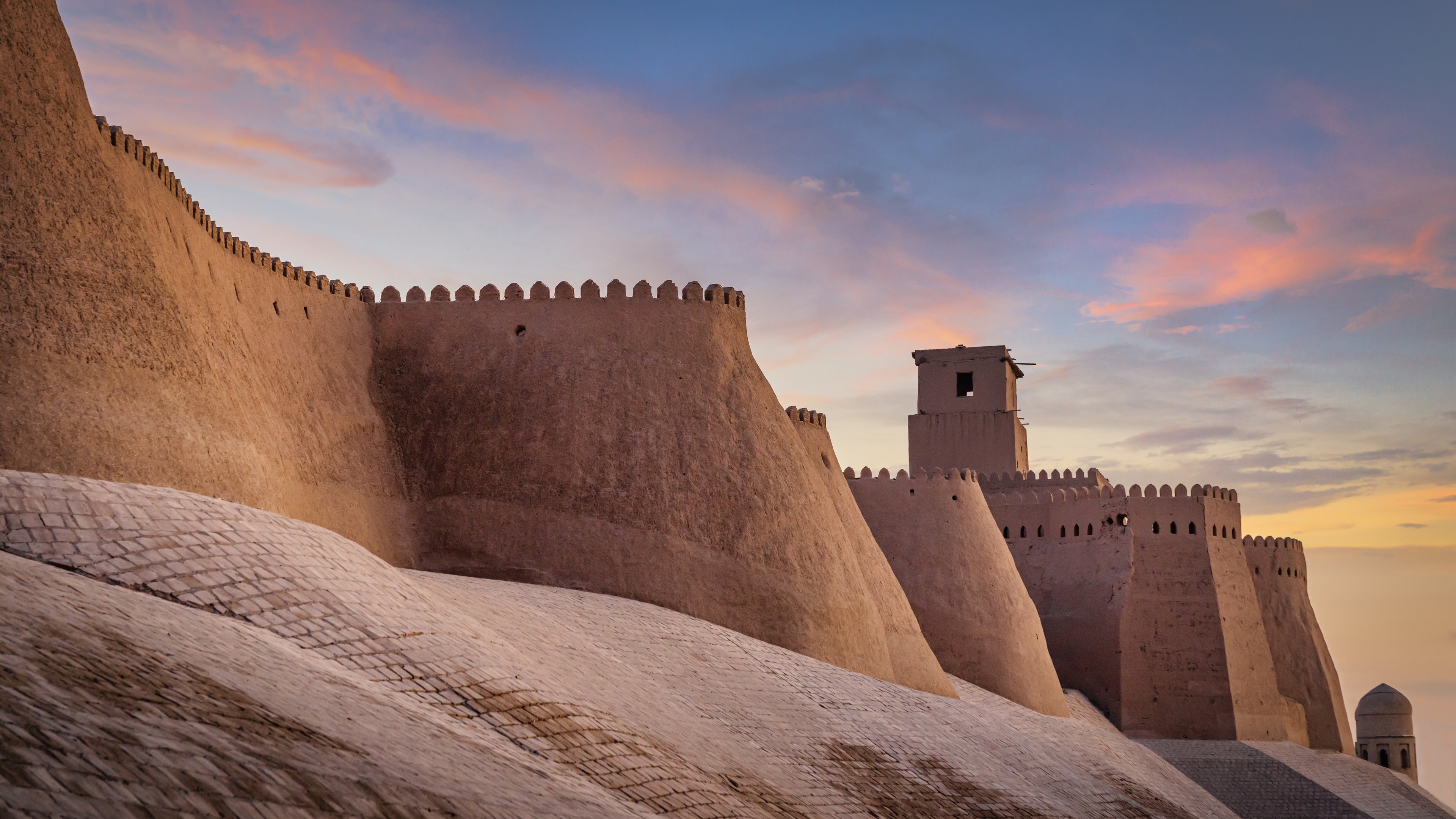Sunset light on the fortified mudbrick walls of Ichan Kala, Khiva, one of Uzbekistan&rsquo;s top UNESCO sites