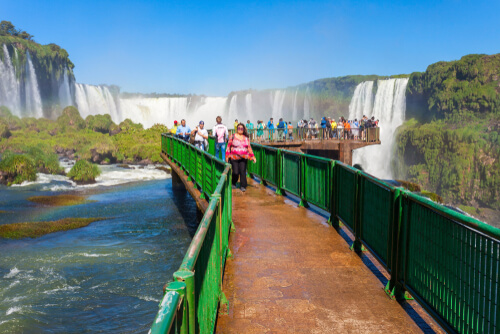 Tourists cross a bridge over the stunning natural wonder that is the Iguazu Falls.