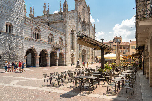 View of Duomo square with a traditional Italian street cafe in the historic centre of Como.