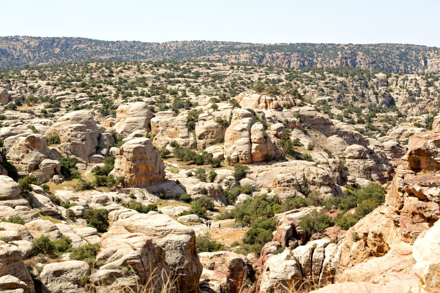 The scenic rocky valley of the Dana Biosphere Reserve with tourists exploring.