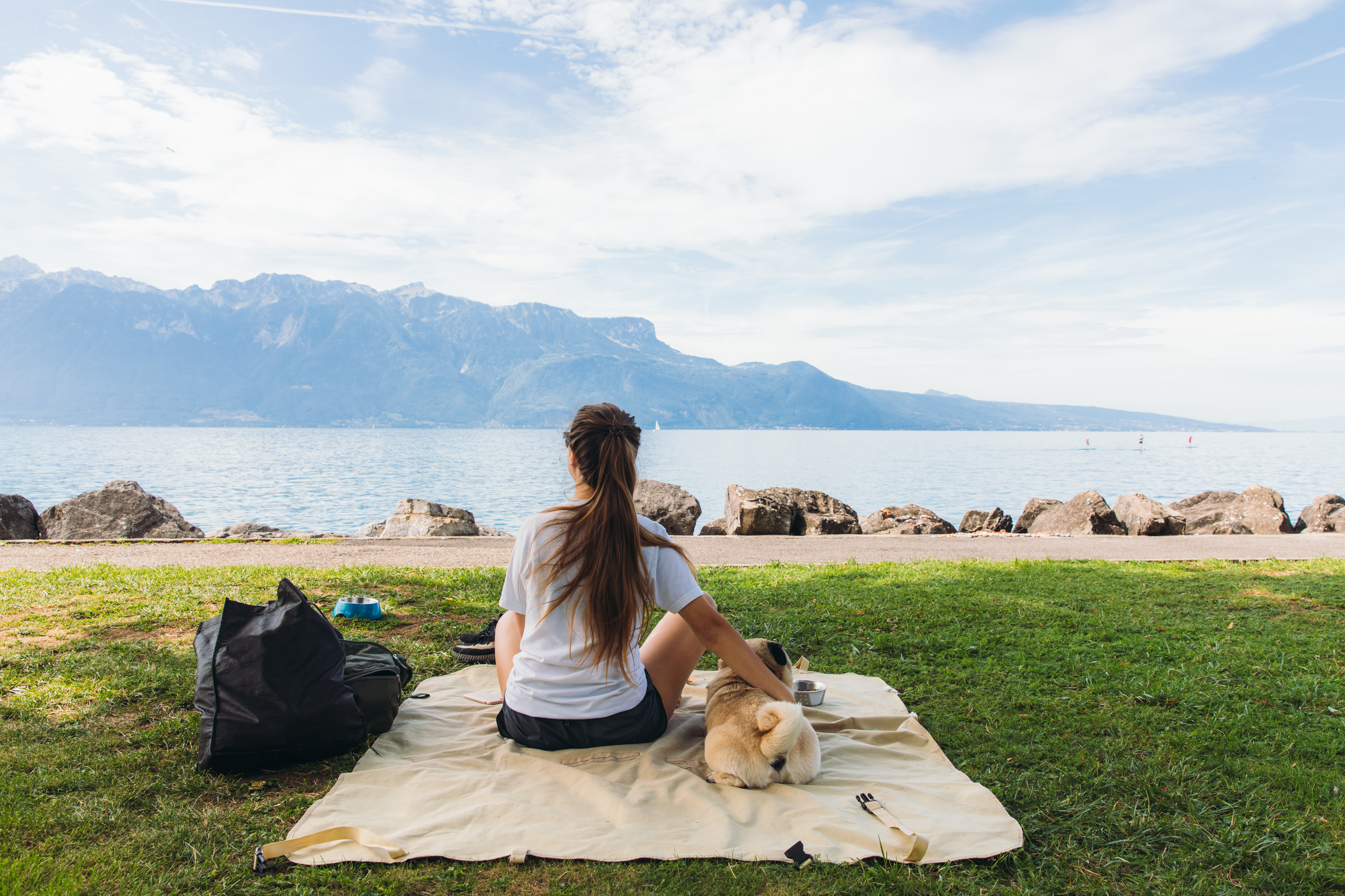 A peaceful summer morning by Lake Geneva, with a woman and her dog soaking up the views