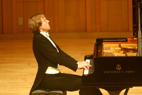 Professor Jan Jiracek von Arnim playing a piano on stage.
