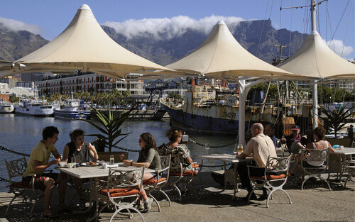 Customers eating and drinking at the V&A waterfront and harbour Cape Town South Africa