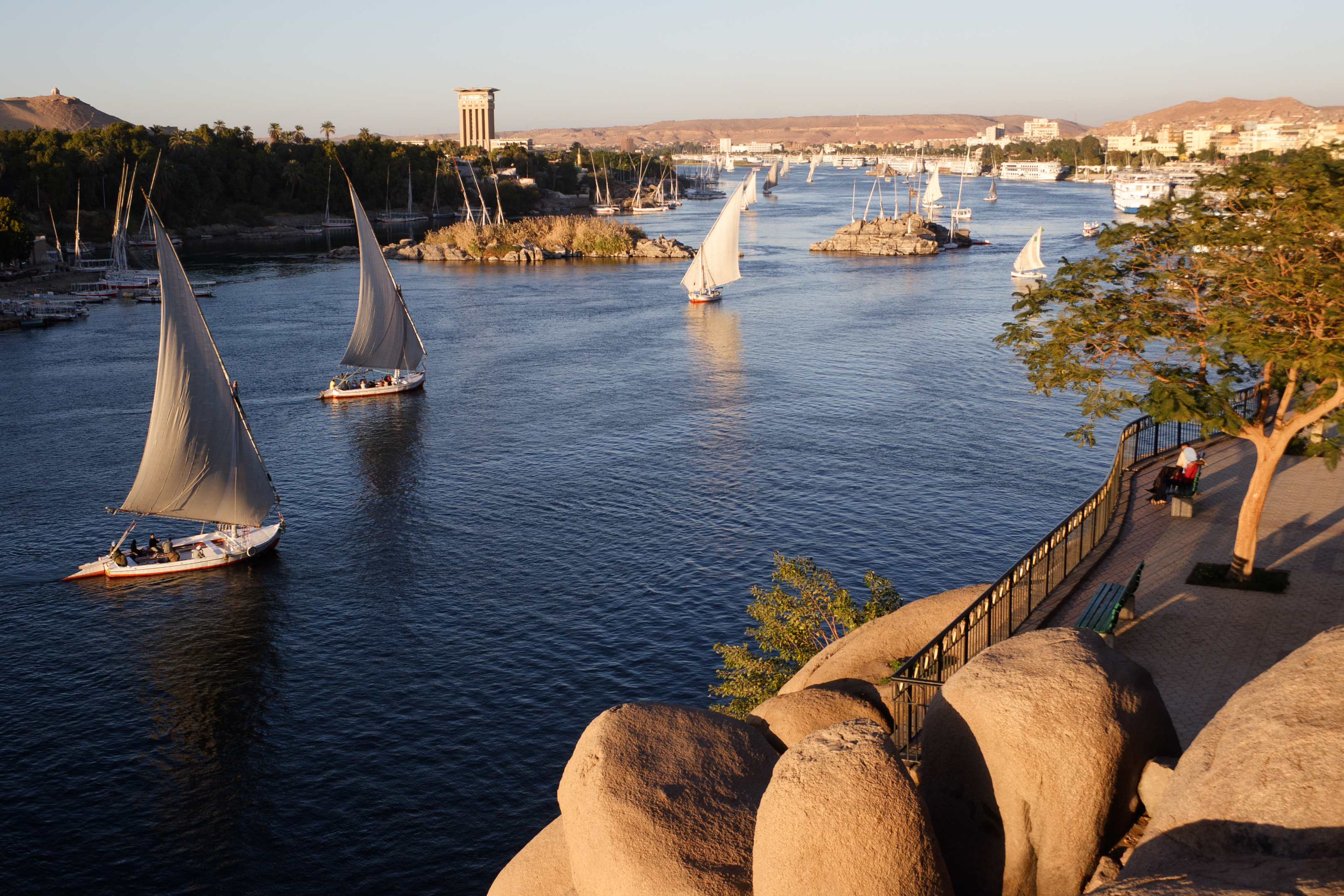 Traditional boats sailing on the Nile River in Aswan, Egypt
