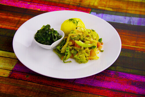 A Kenyan traditional cabbage dish with sukuna wiki and ugali or maize.