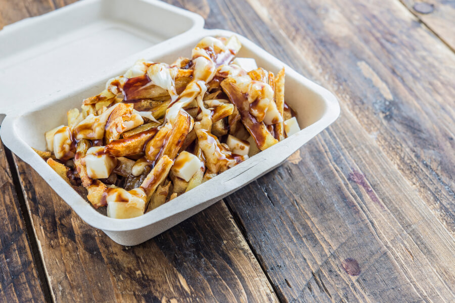 Poutine, a beloved Canadian dish made with fries, gravy, and cheese curds, is a must-try food