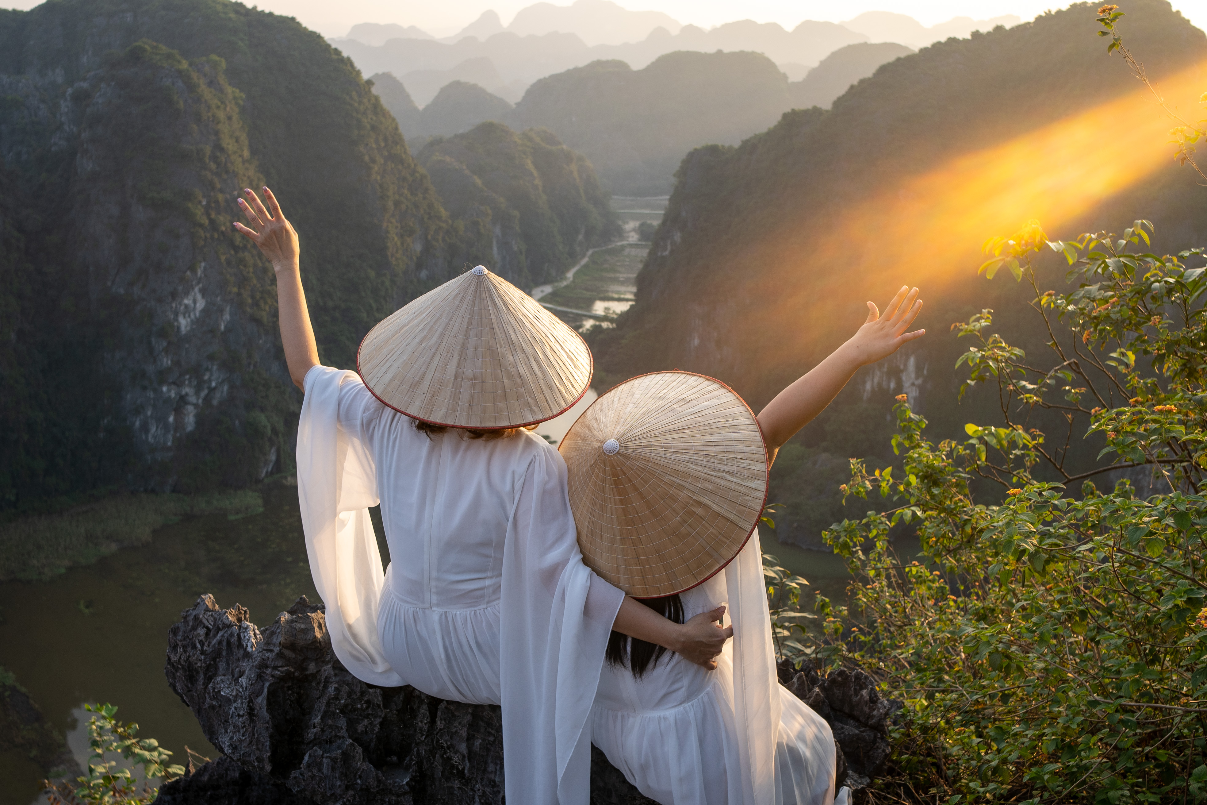 A mother and daughter wear traditional Vietnamese attire while visiting Ninh Binh, a scenic region in North Vietnam