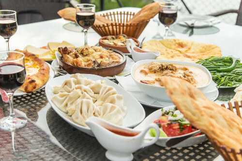Georgian dishes with Khachapuri and wine on the table in Tbilisi.