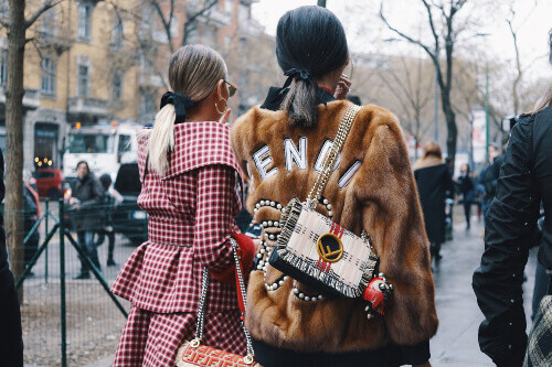 Fashionable women wearing Fendi clothing at Milan Fashion Week.