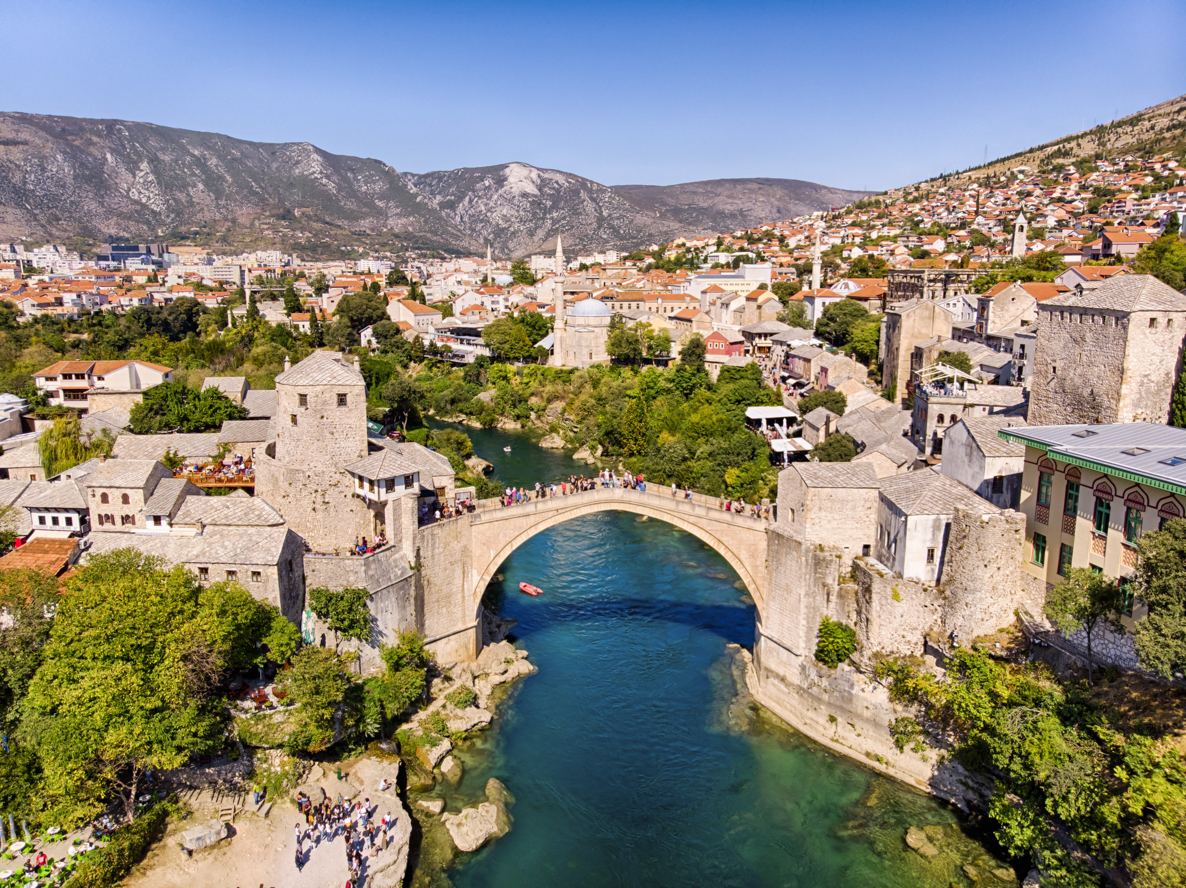 Riverside view of Mostar with traditional buildings and bridge in Bosnia and Herzegovina