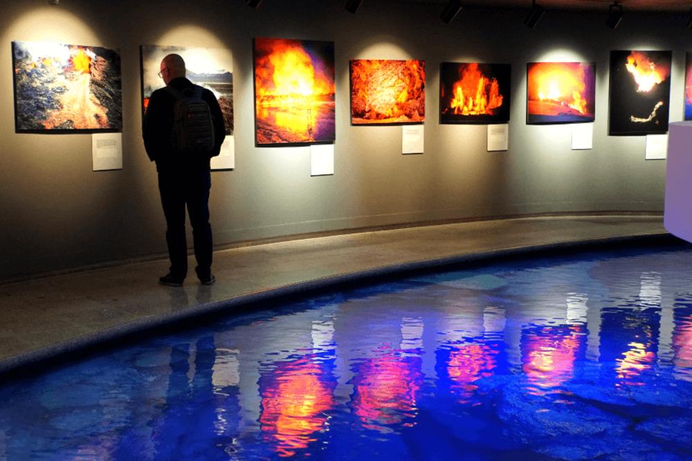 A tourist studying the photo collection of volcanic eruptions inside Perlan Planetarium and Exhibition Centre.