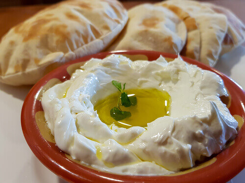 Labneh: A Jordanian dip made from strained yoghurt, served with olive oil, herbs, and warm bread as part of a traditional mezze.