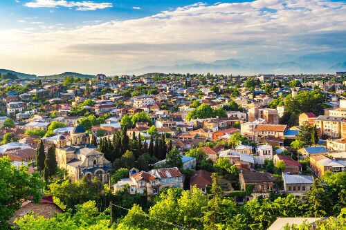Traditional houses and rooftops under the blue sky with a Catholic Cathedral seen in the foreground.