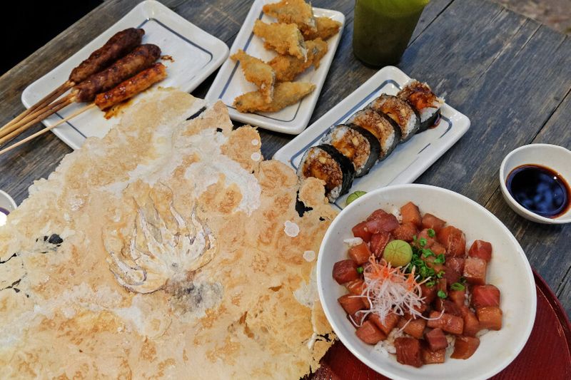 Izakaya food such as Chicken Teriyaki skewers, battered deep fried fish, Sushi Maki rolls, Sashimi rolls, and Senbei