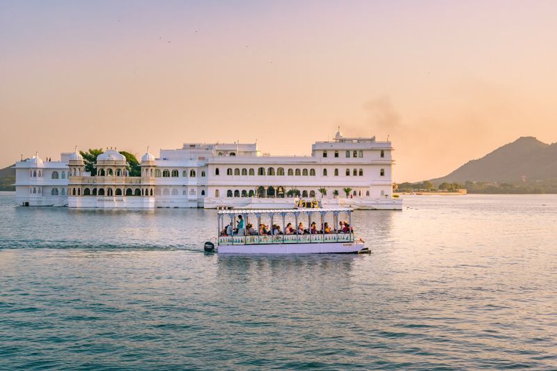 The Lake Palace that was called Jag Niwas with tourist boat cruising along.