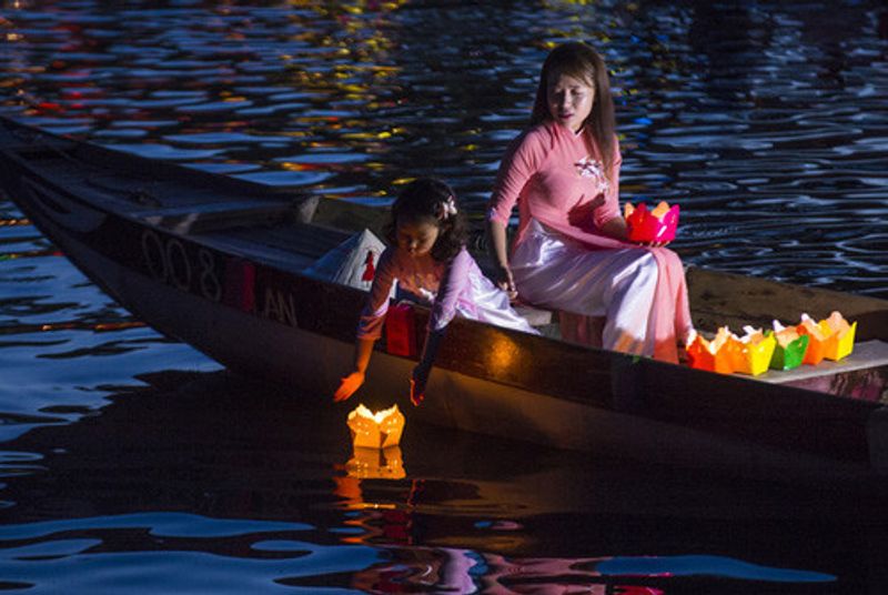 A Vietnamese girl releasing a lantern into the river in Hoi An, Vietnam.