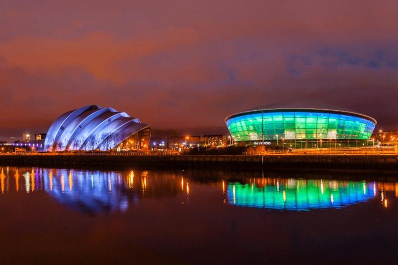 The SSE Hydro Arena and SEC Armadillo illuminated by the River Clyde at night