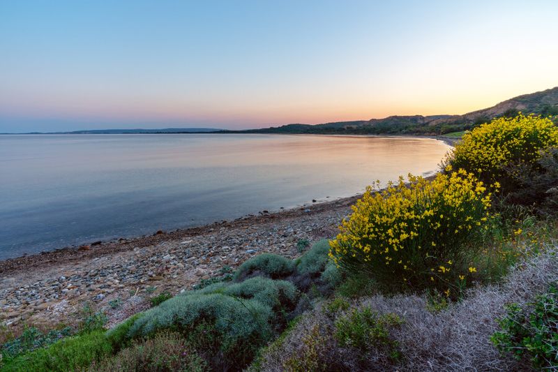 The serene Anzac Cove beach at sunset.