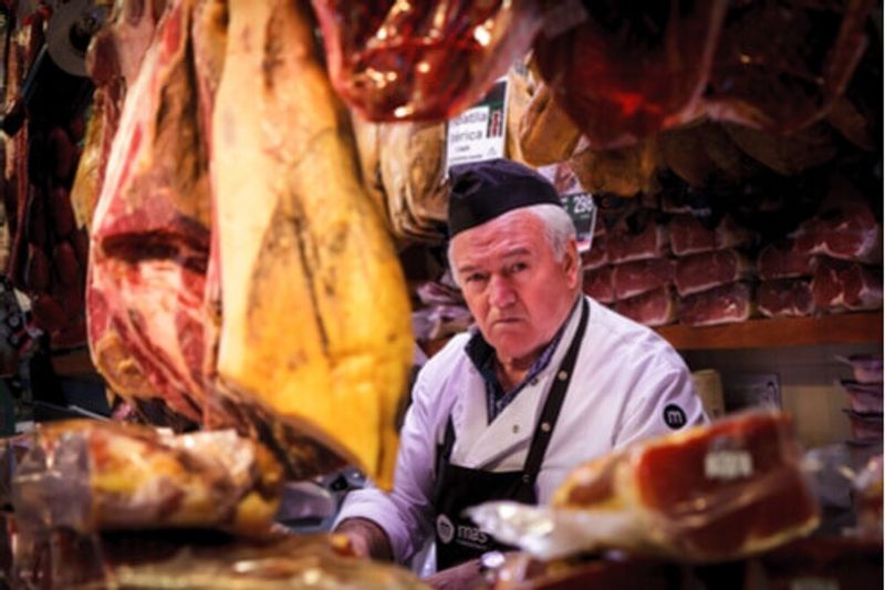 A local Butcher in front of Jamon Market, Spain.