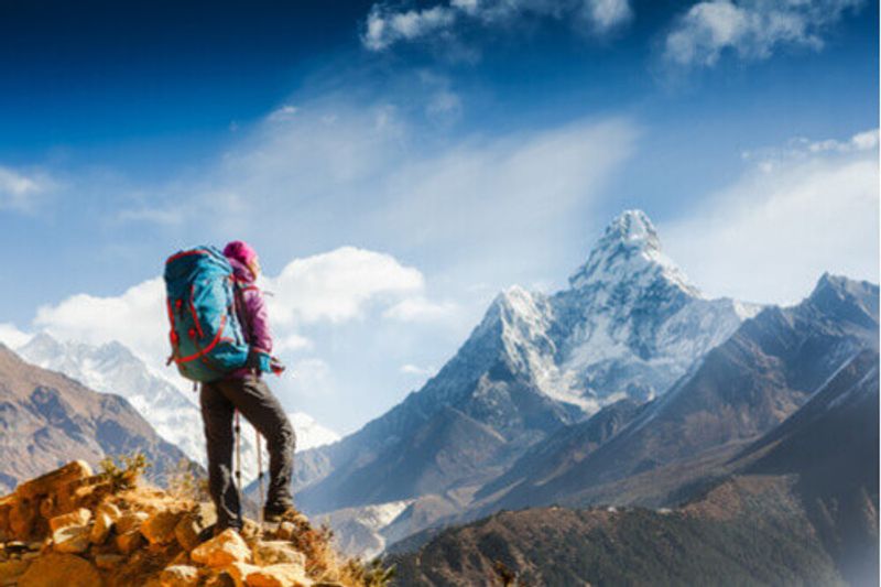 A woman hikes against the stunning backdrop of mountains in Nepal.