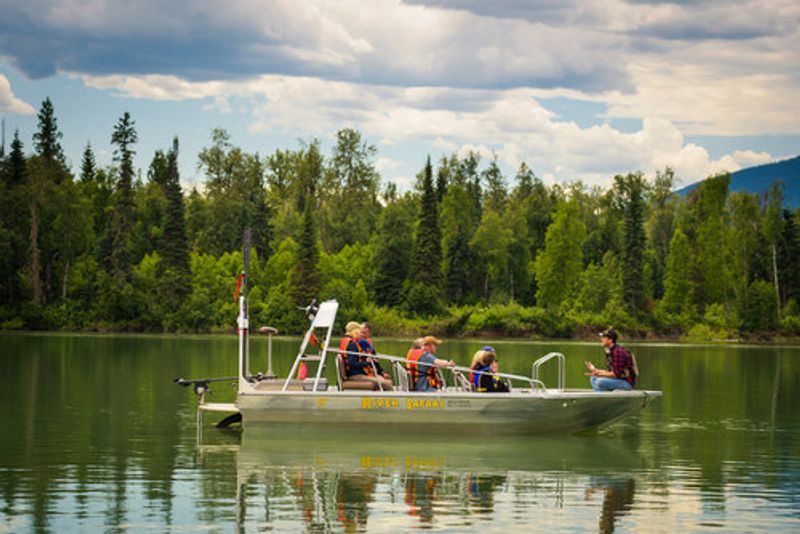 Tourists on a boat during a river safari tour listening to the tour guide in the Blue River.