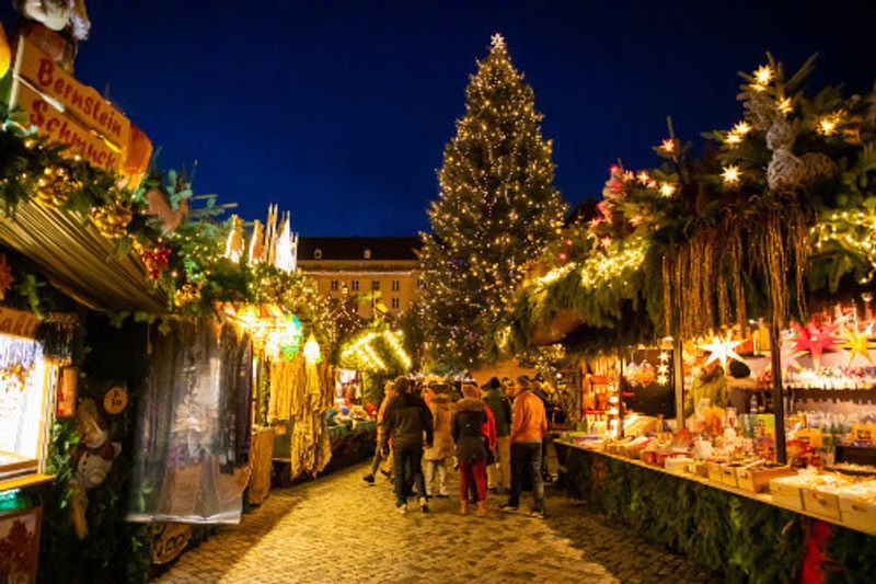 Buying trinkets at the Christmas Market, Striezelmarkt, in Dresden.