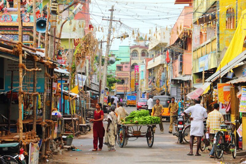 People go about thier day-to-day lives in a colourful street of India.