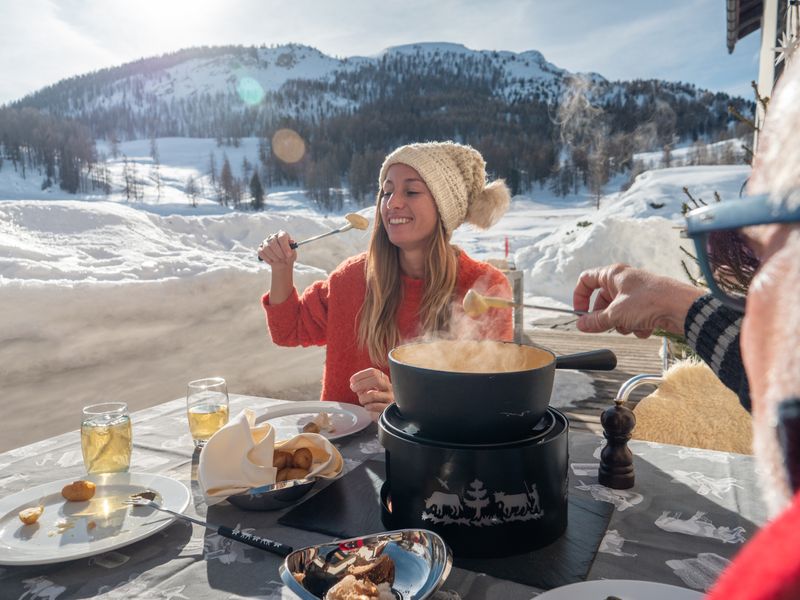 Sharing Swiss fondue outdoors with stunning alpine views in winter