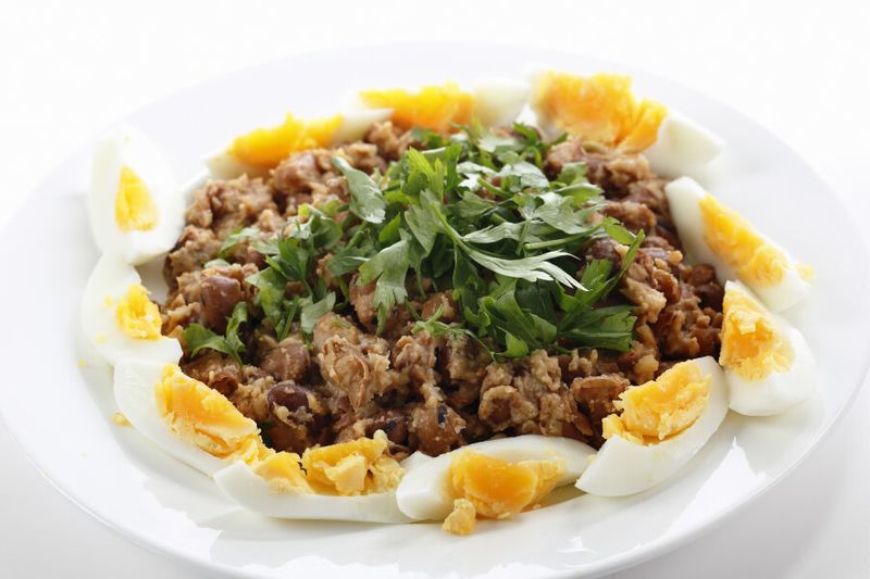 Egyptian foul or ful medammes on a plate garnished with sliced hard-boiled eggs